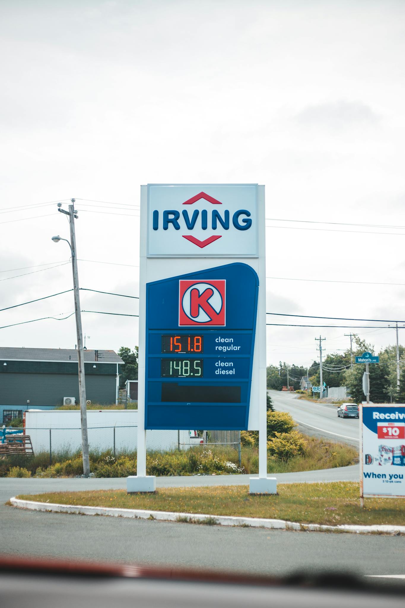 Vertical shot of a gas station sign showing fuel prices, including Irving branding.